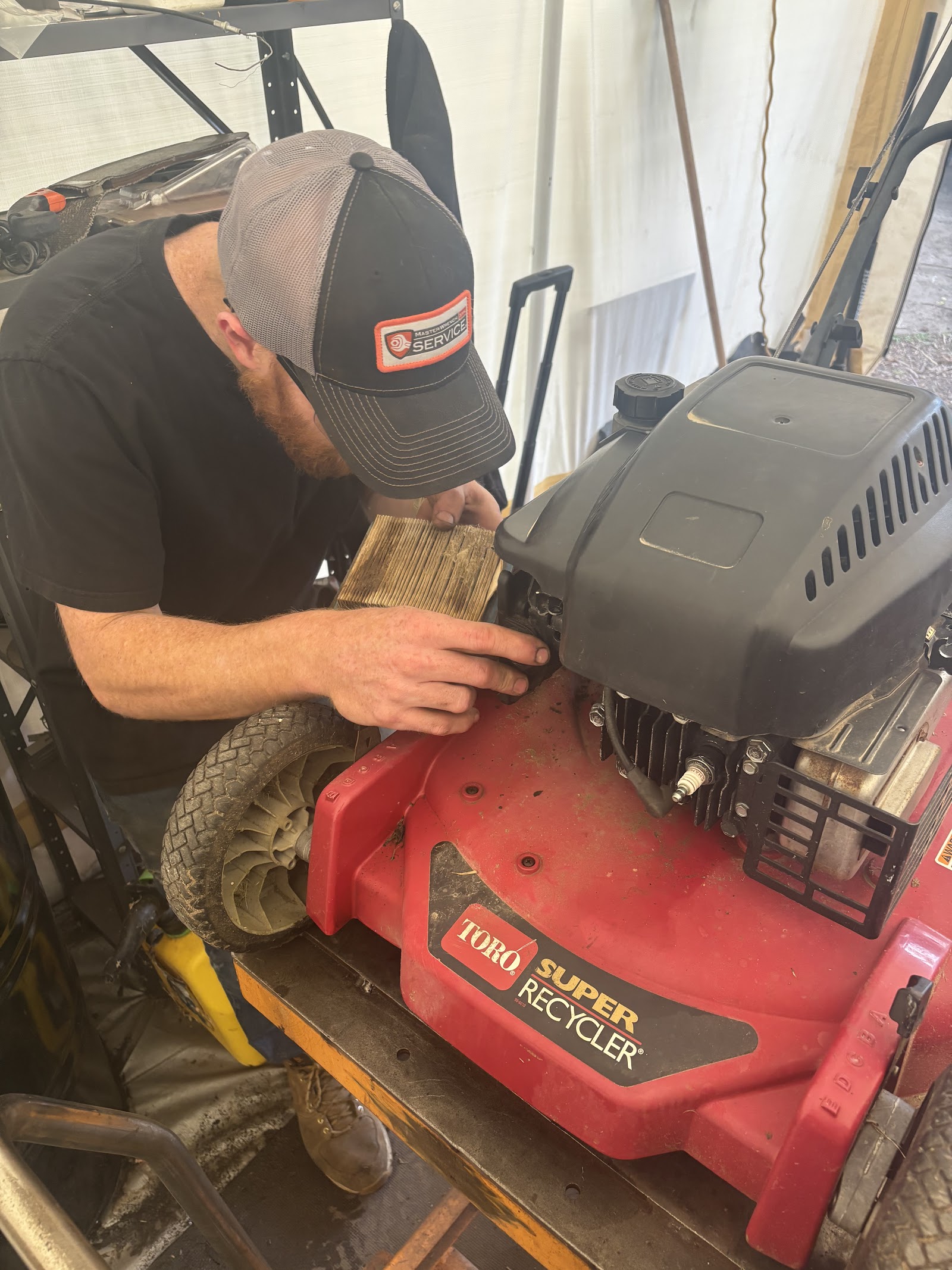 Kevin in his Bench'n Wrench cap working on a Toro mower engine