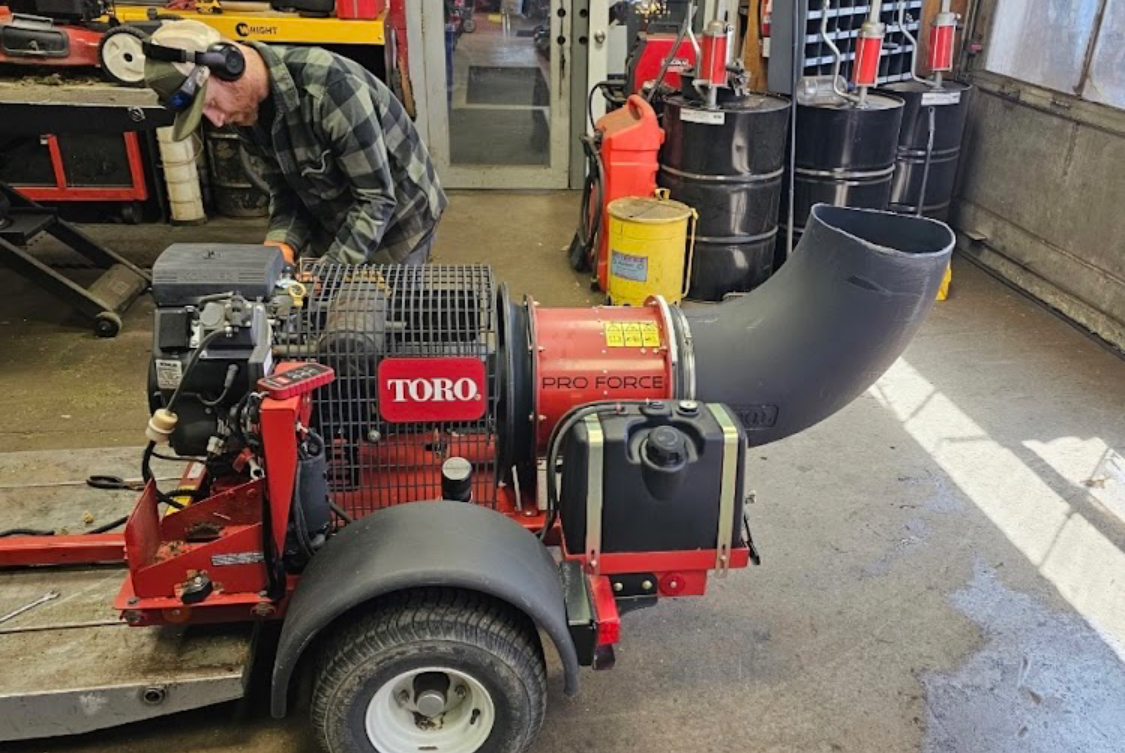Kevin servicing a Toro Pro Force debris blower inside the Bench'n Wrench shop